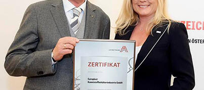 Herr Helmuth Kubin nimmt die Auszeichnung zum Leitbetrieb von Frau Monica Rintersbacher entgegen.
